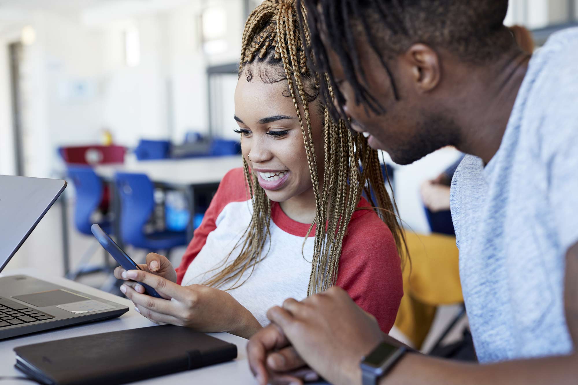 Two students both looking at a phone 